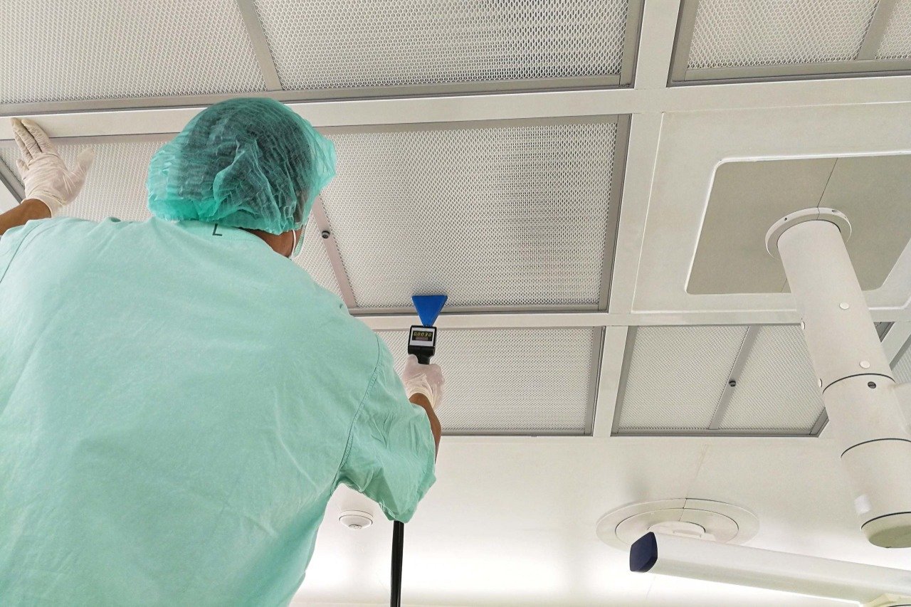 Técnico midiendo integridad de filtro HEPA en cuarto limpio médico